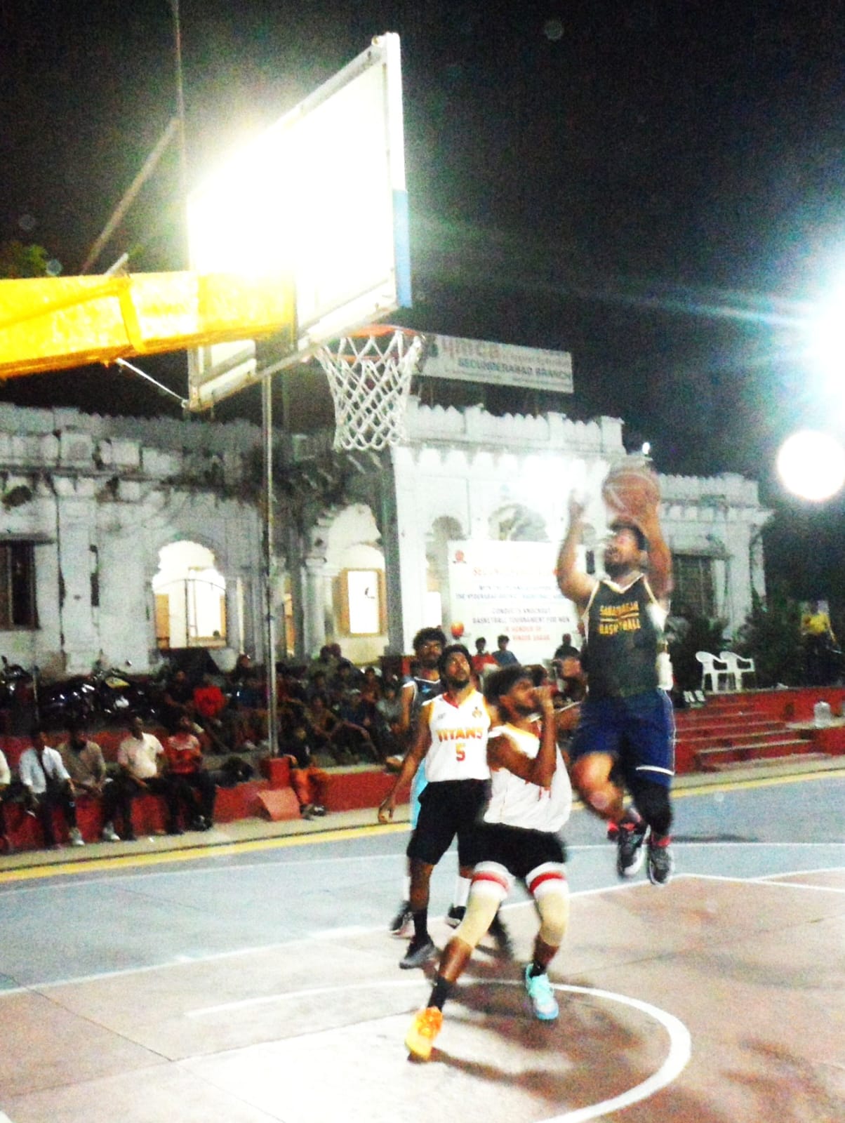 GHMC Sanathnagar's Nikhil is airbone as he attempts a shot against Titans