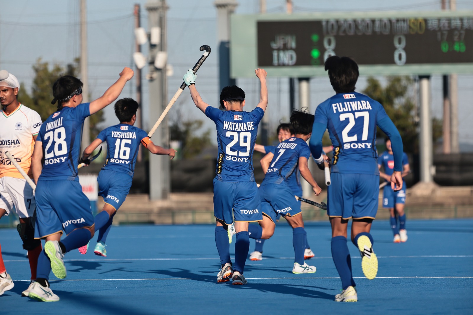 Japan celebrate a goal against India