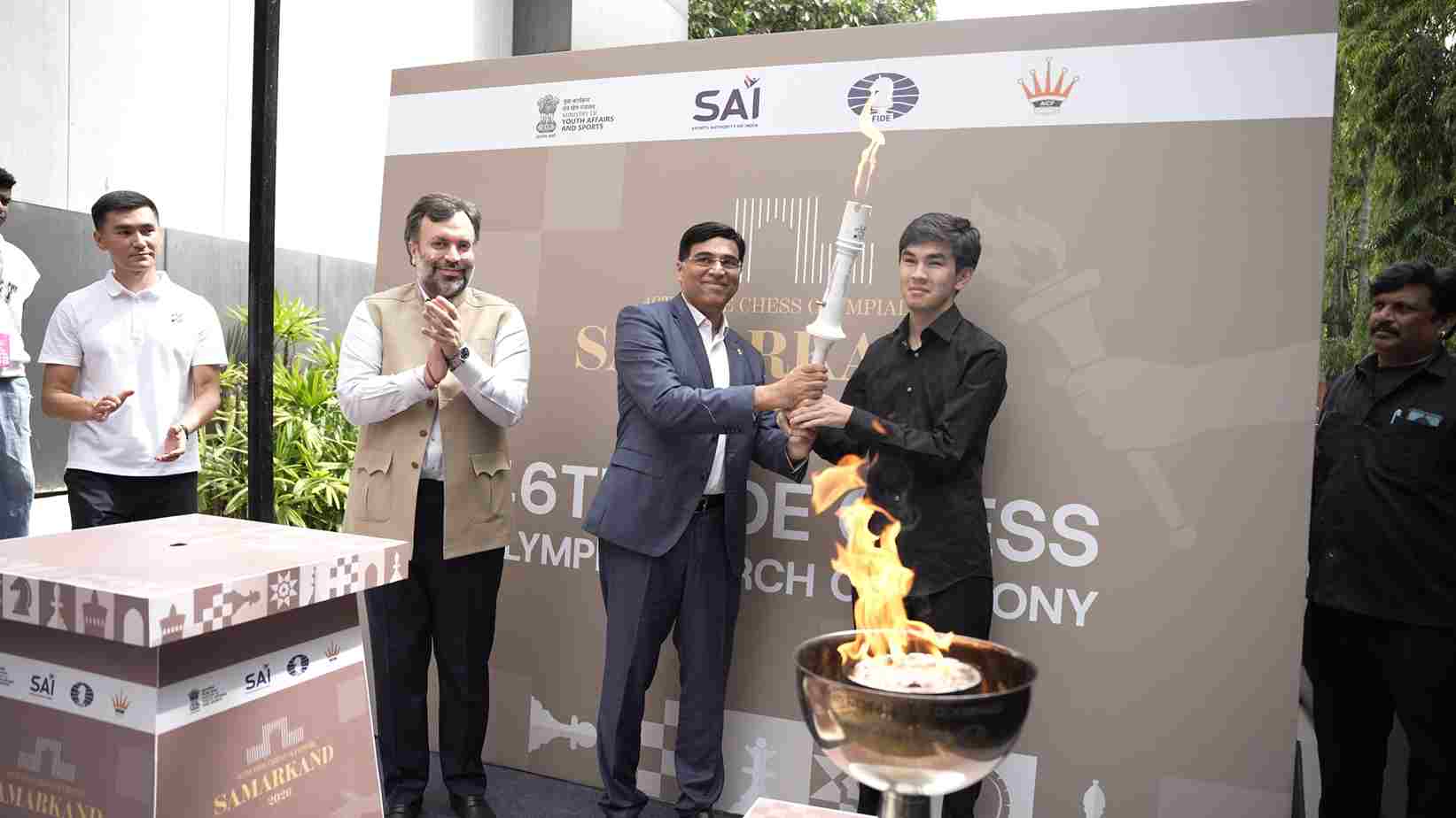 Chess Olympiad ceremonial Torch handed to Uzbek GM Javokhir Sindarov by Anand and Narang