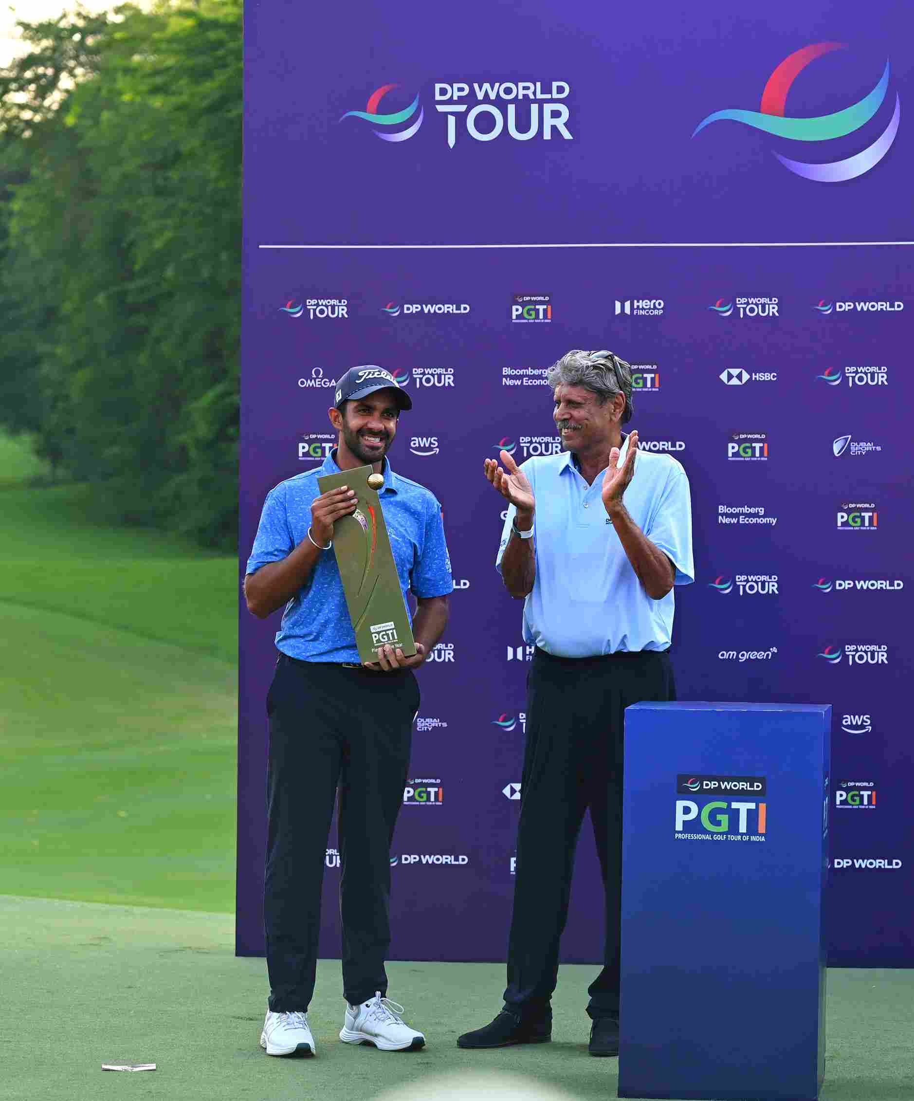 Saptak Talwar receiving the DP World PGTI Order of Merit Trophy from Kapil Dev, president, DP World PGTI